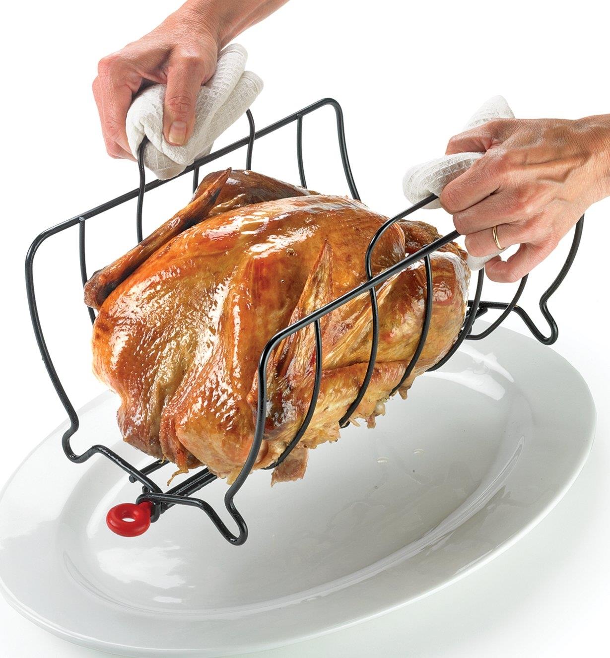 Transferring a roasted chicken to a platter by carrying the rack by its handles