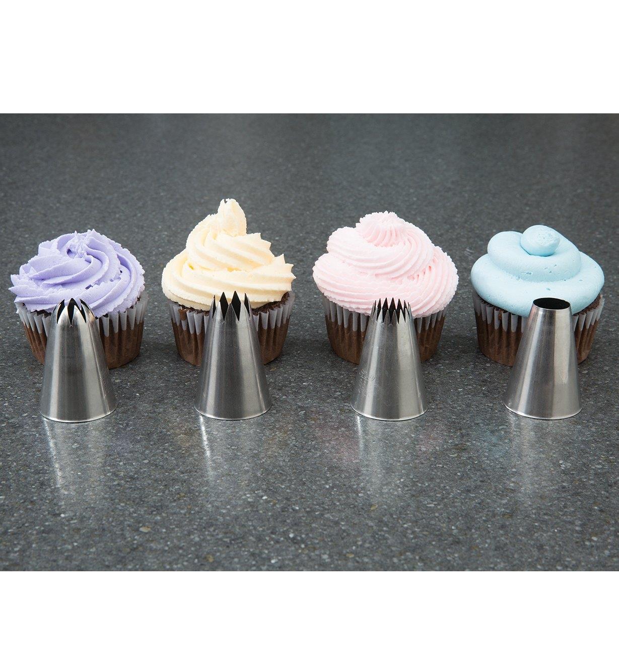 Large Icing Tips placed in front of frosted cupcakes as examples of the patterns they produce