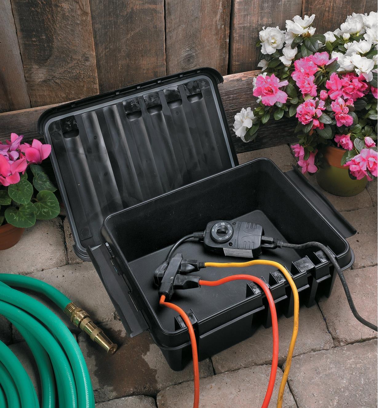 Electrical cords in a garden connected inside a Dribox with the lid off