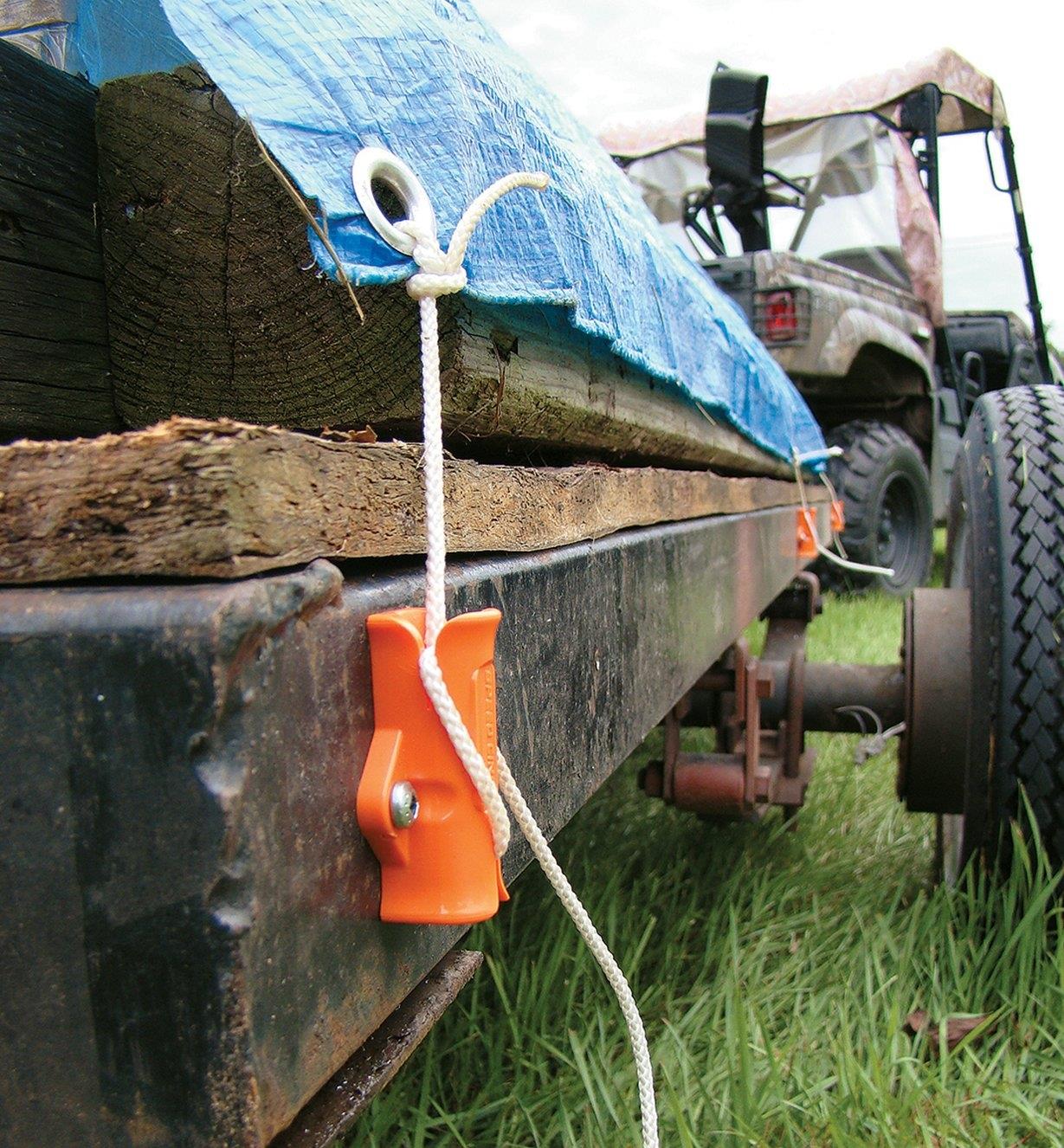 Speed Cinch Tie-Down Utility Cinch secures a tarp over a load on a trailer