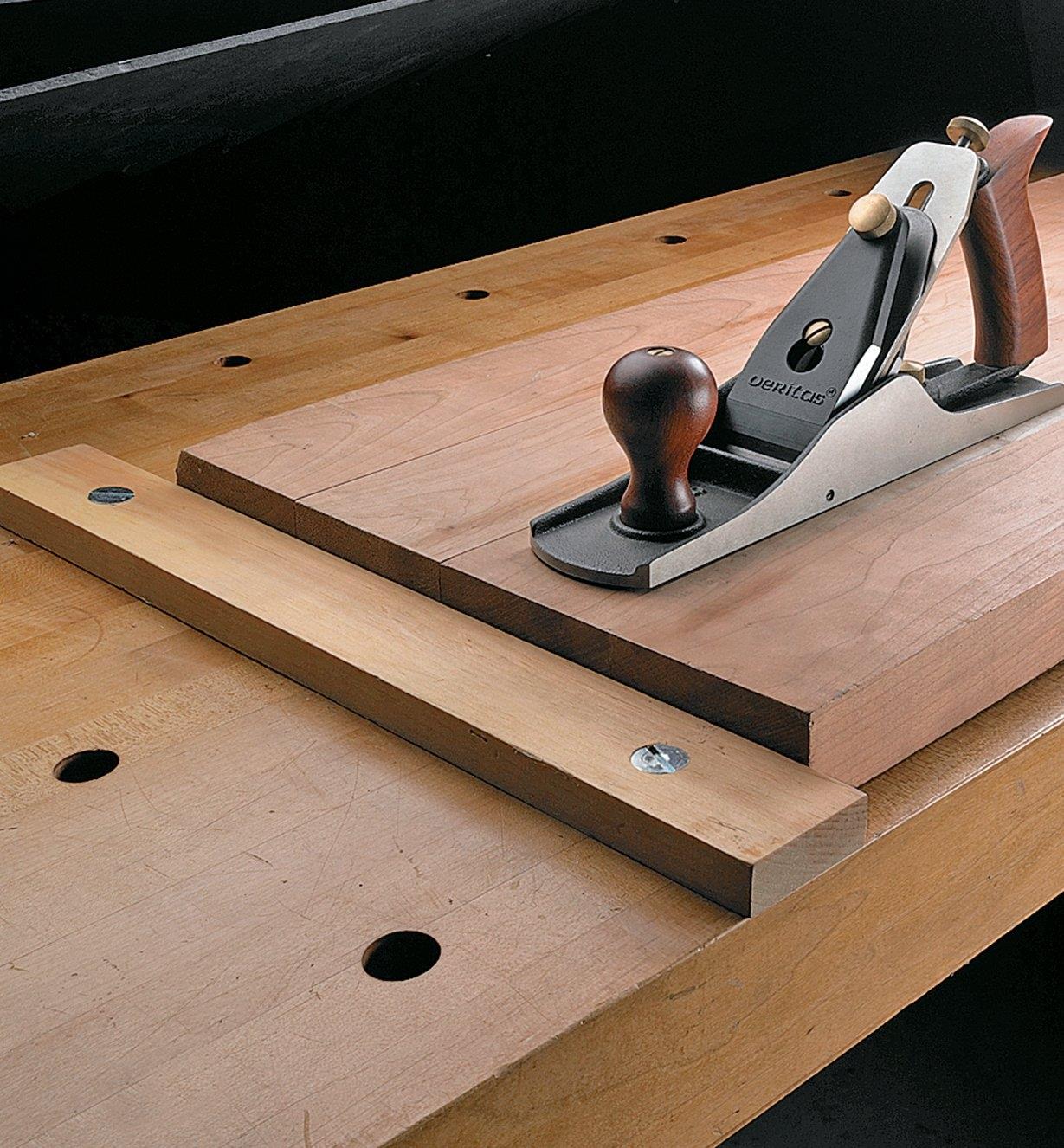 Planing stop attached to a workbench with two bench anchors and fasteners