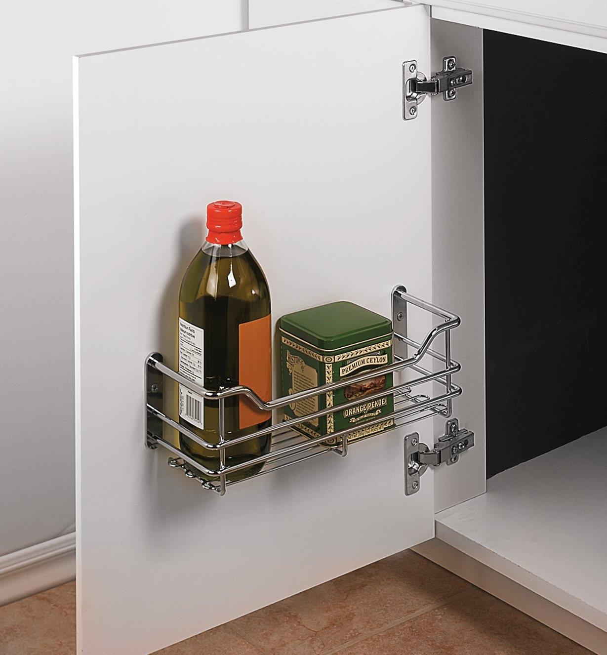 Utility Basket mounted inside a cupboard door, holding tea and cooking oil