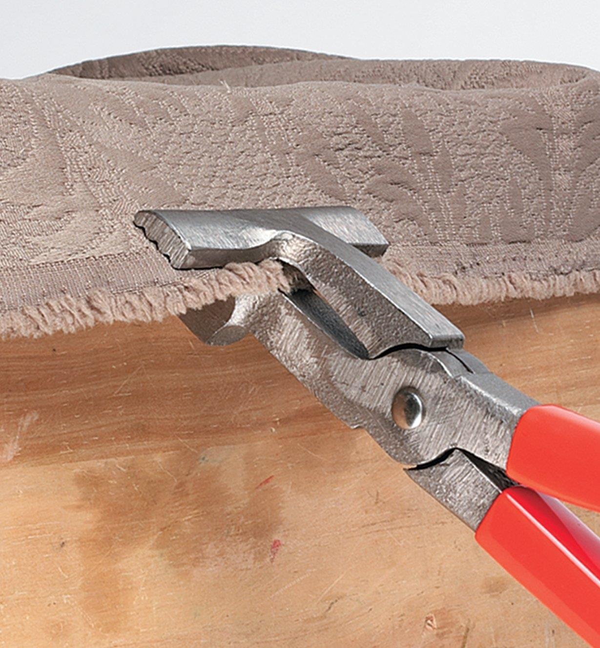 Upholsterer's Pliers holding the edge of upholstery fabric