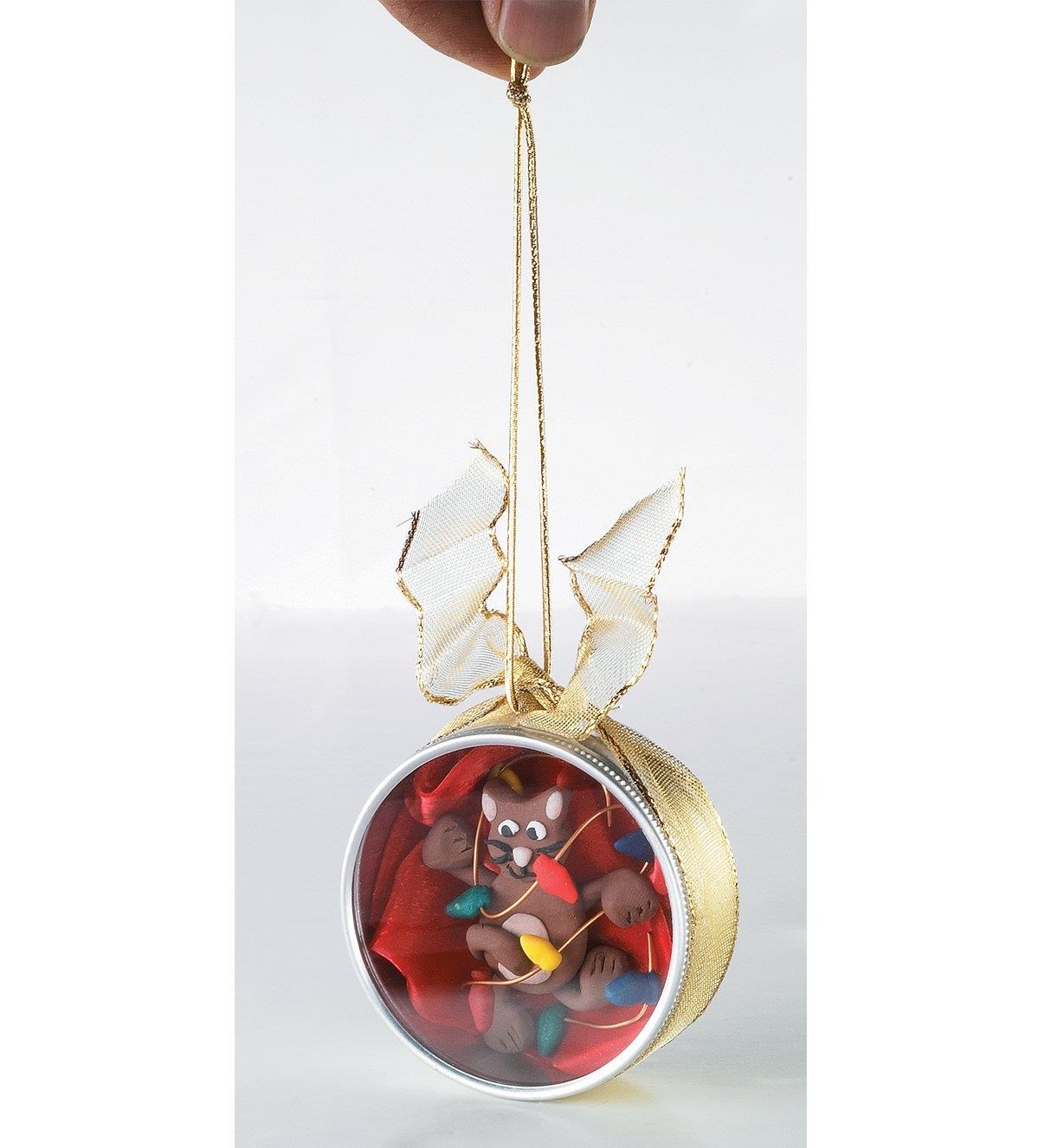 A holiday ornament made with a polymer clay cat inside a Watchmaker's Case