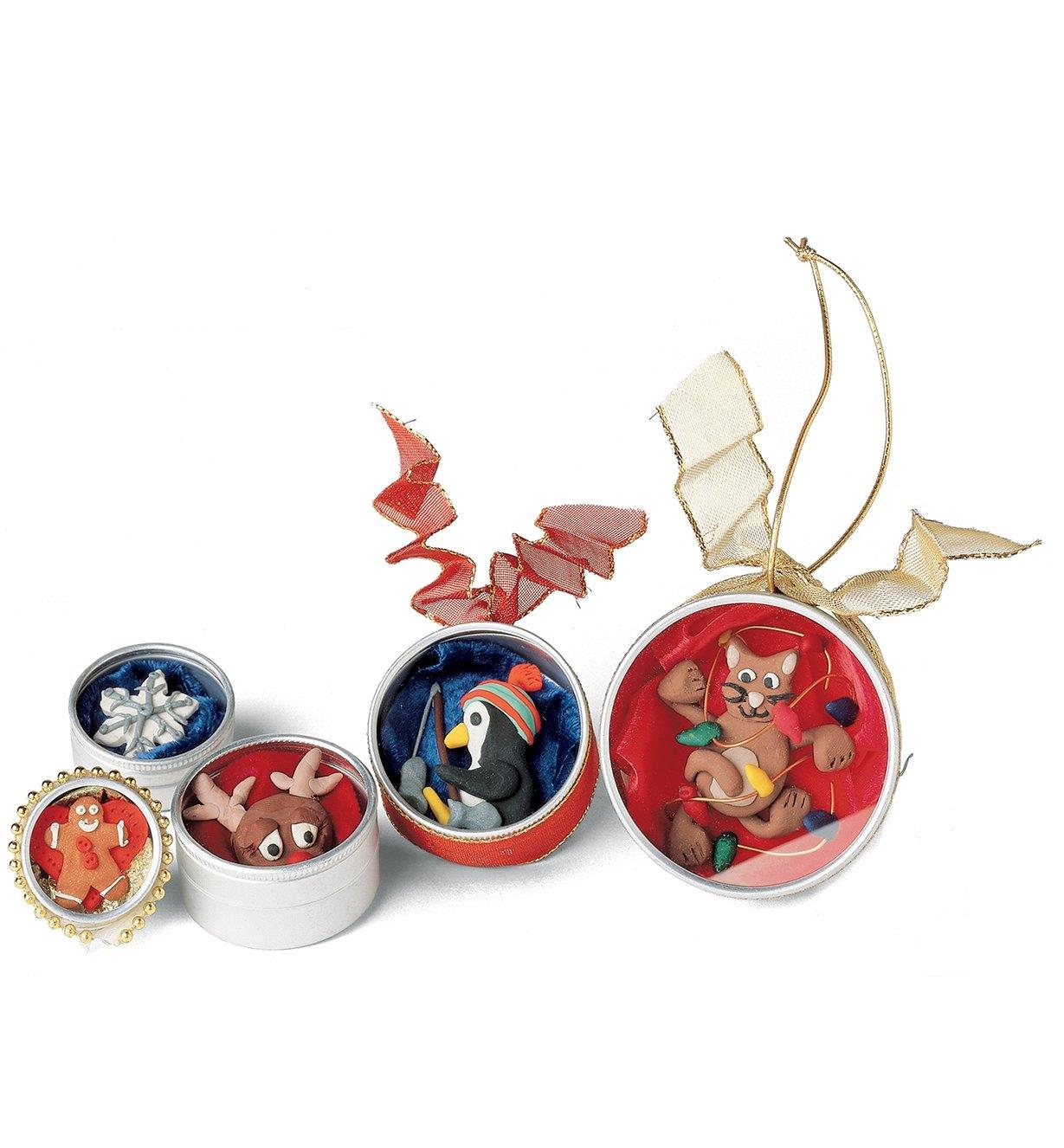 Several holiday ornaments made with polymer clay figures inside watchmaker's cases