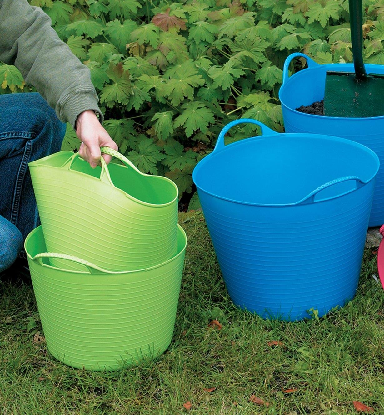 A woman lifts one tubtrug out of another tubtrug