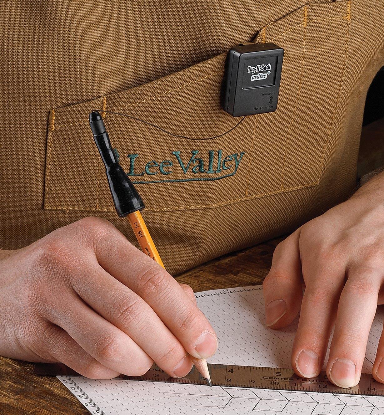 Drawing a sketch with a pencil held in a Tug-N-Back Writer Pencil Holder attached to an apron pocket