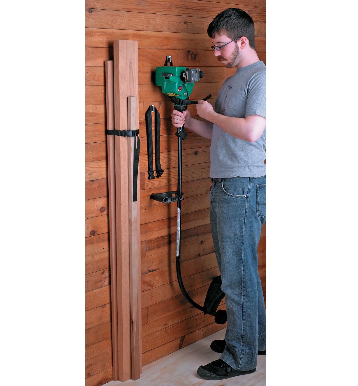 Hanging a string trimmer on a wall using a Wall-Mount Storage Straps & Brackets
