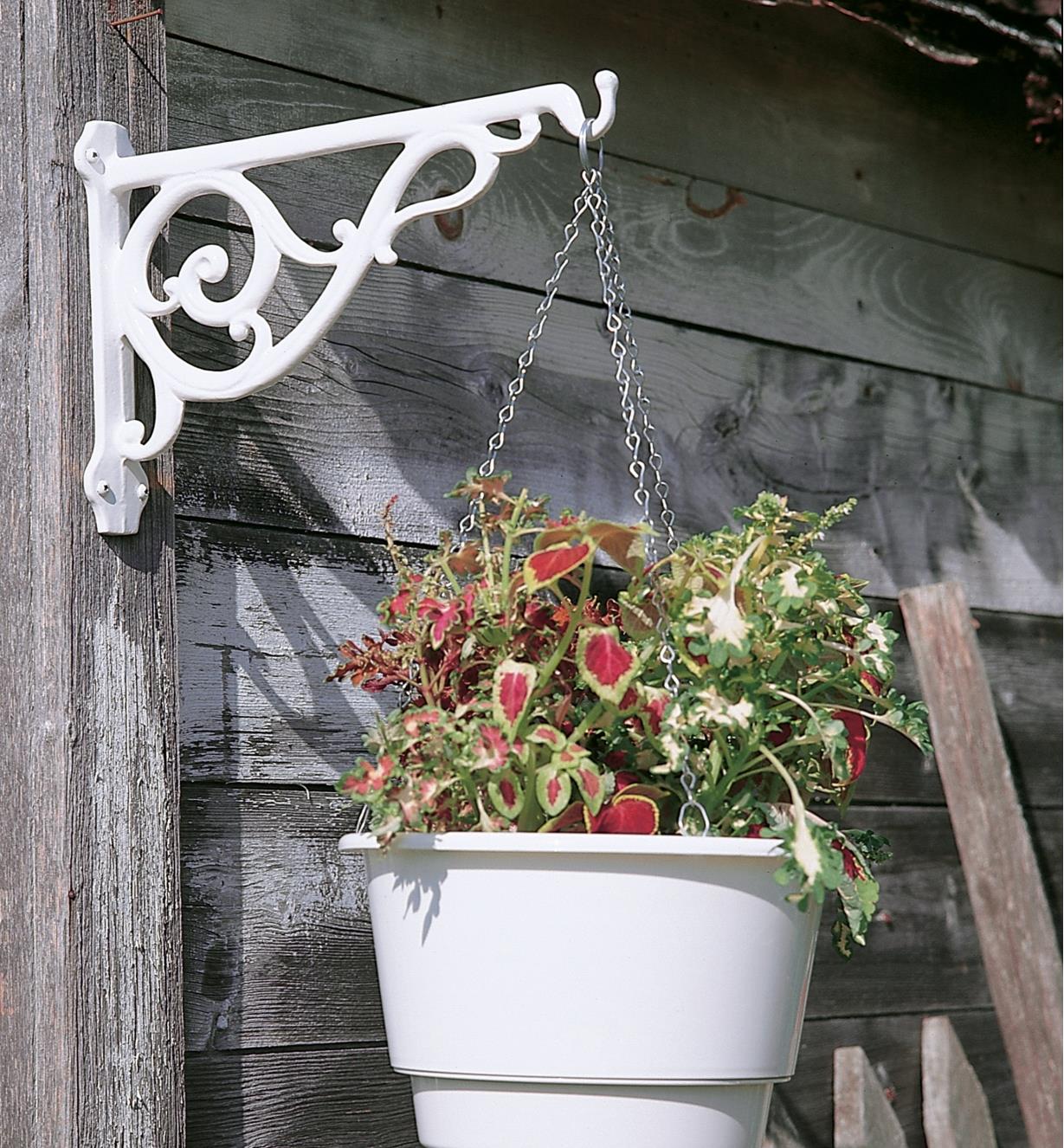 White Victorian Wall Bracket holding a hanging basket on an outdoor post