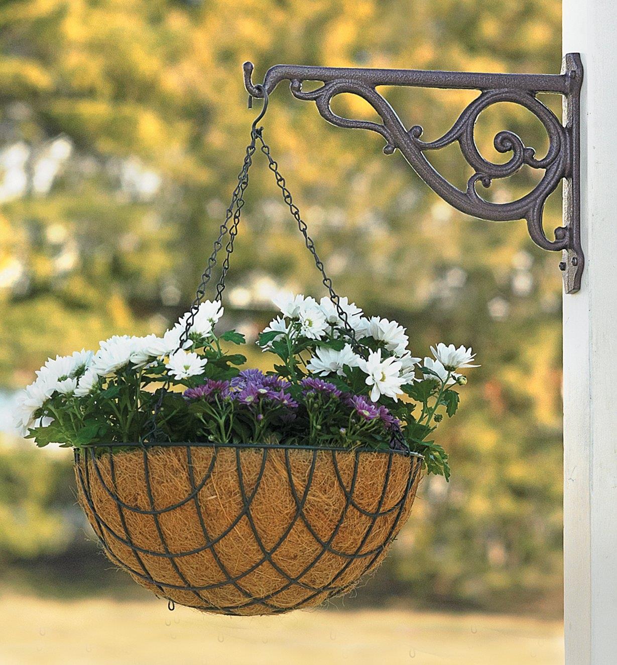 Bronze Victorian Wall Bracket holding a hanging basket on an outdoor post