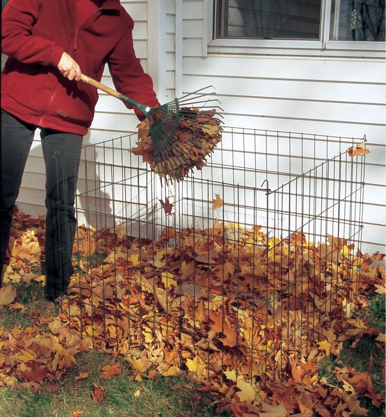 A woman forks leaves into a Wire Compost Bin