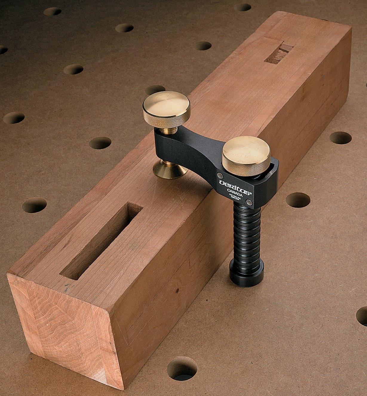 Surface clamp holding a block of wood on a workbench
