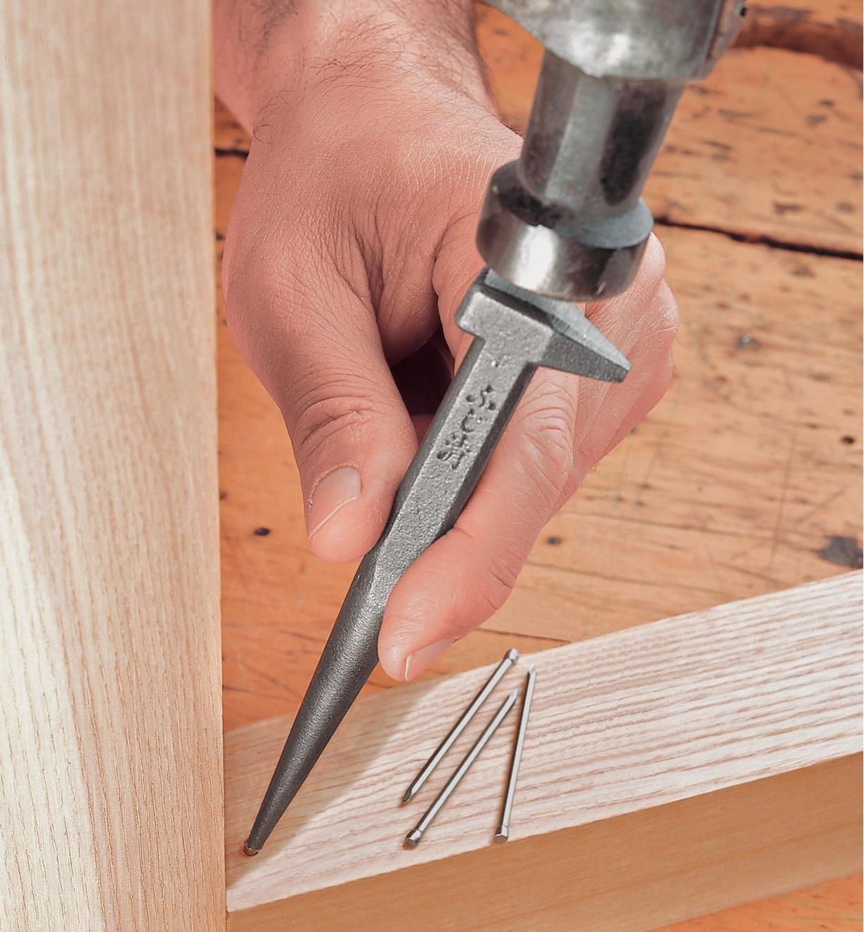 Using a Japanese Nail Set to set a nail in the corner of a frame