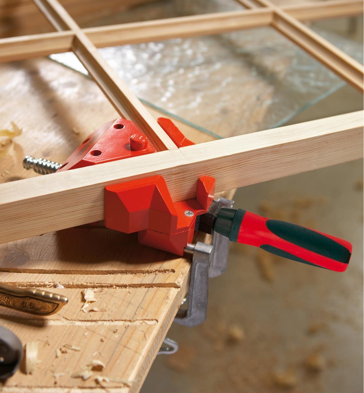 A Bessey small corner and T clamping fixture holding two pieces of a panel window frame at 90°