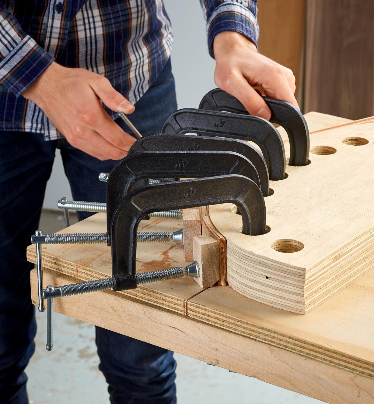 Bessey heavy-duty C-clamps used to secure a bent lamination project to a curved form for glue-up