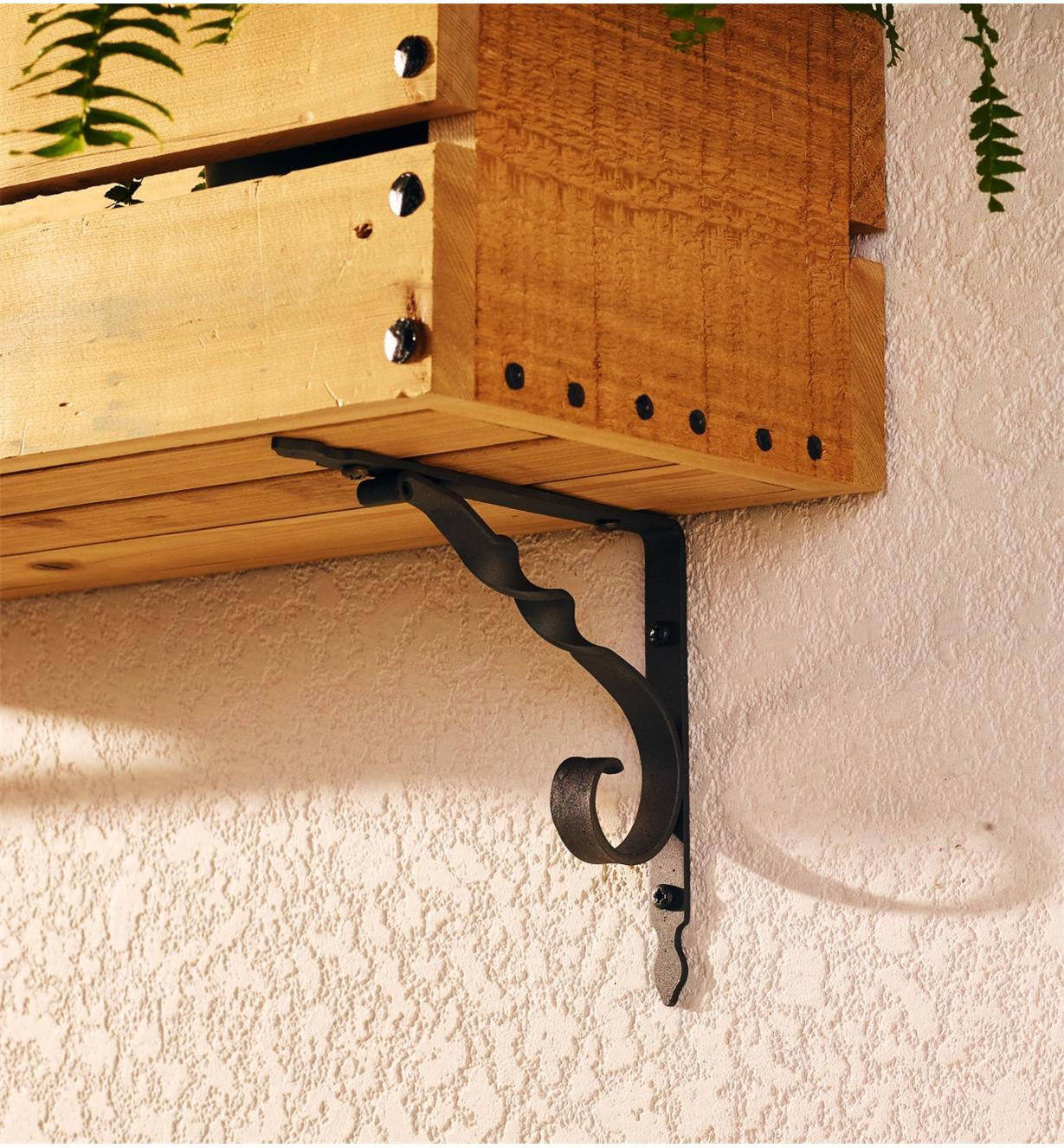 Shelf bracket used to attach a planter box to a wall