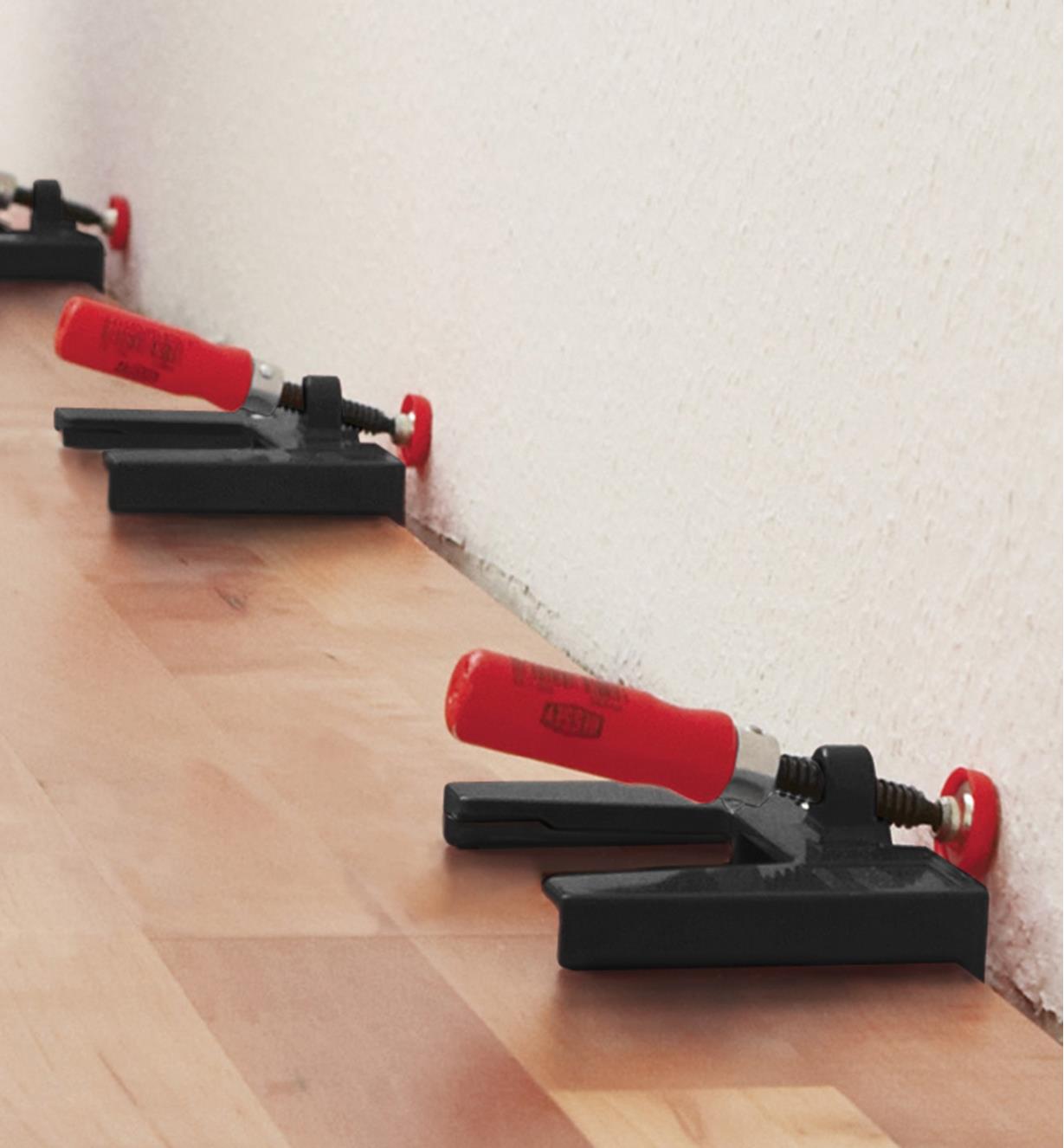 Bessey flooring spacer clamps being used to offset flooring materials from a wall