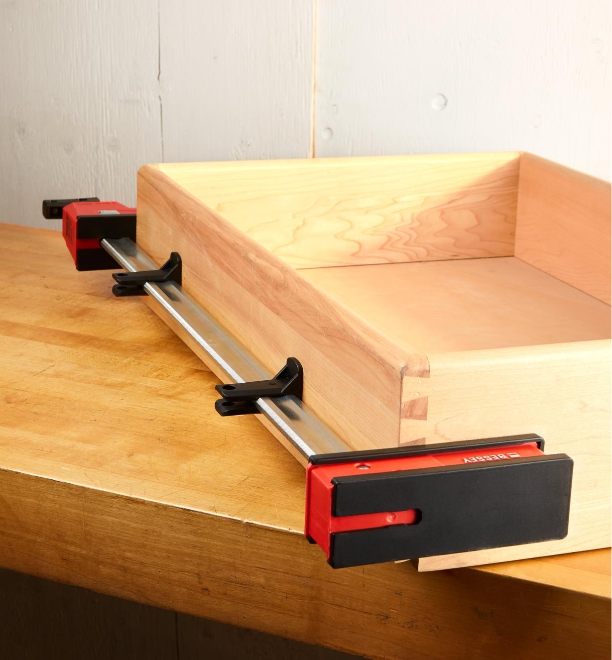 Two Bessey K-Body rail protectors mounted on the rail of K-Body clamp used to hold a drawer assembly