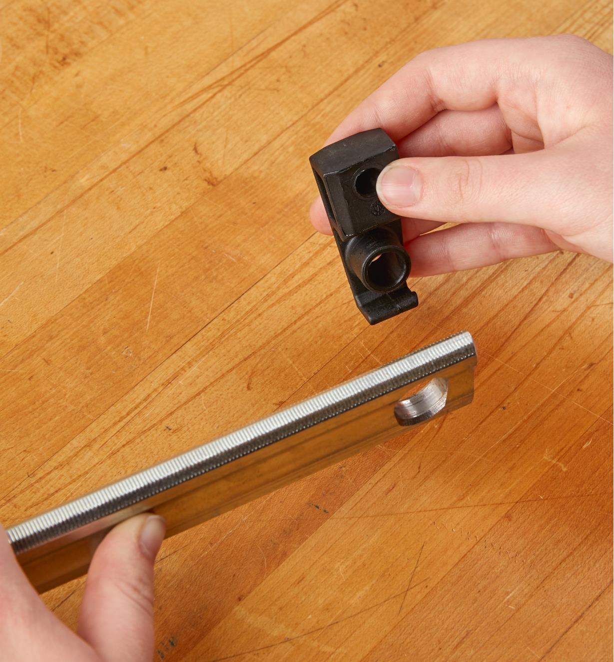 A Bessey rail-end clip being detached from the end of a Bessey K-body clamp rail