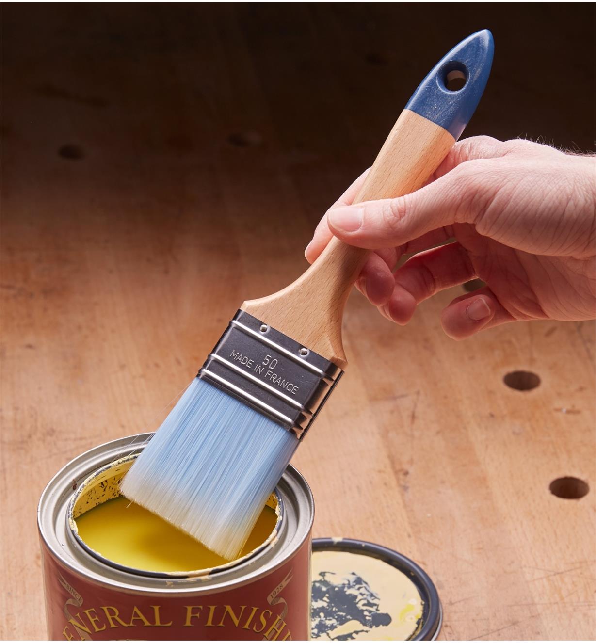 Dipping a Nylon Bristle Brush into a can of paint