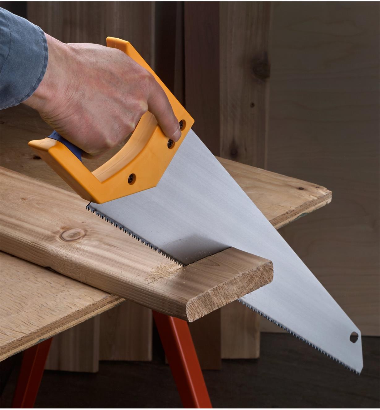 Using a Professional Handsaw to cross-cut a deck board
