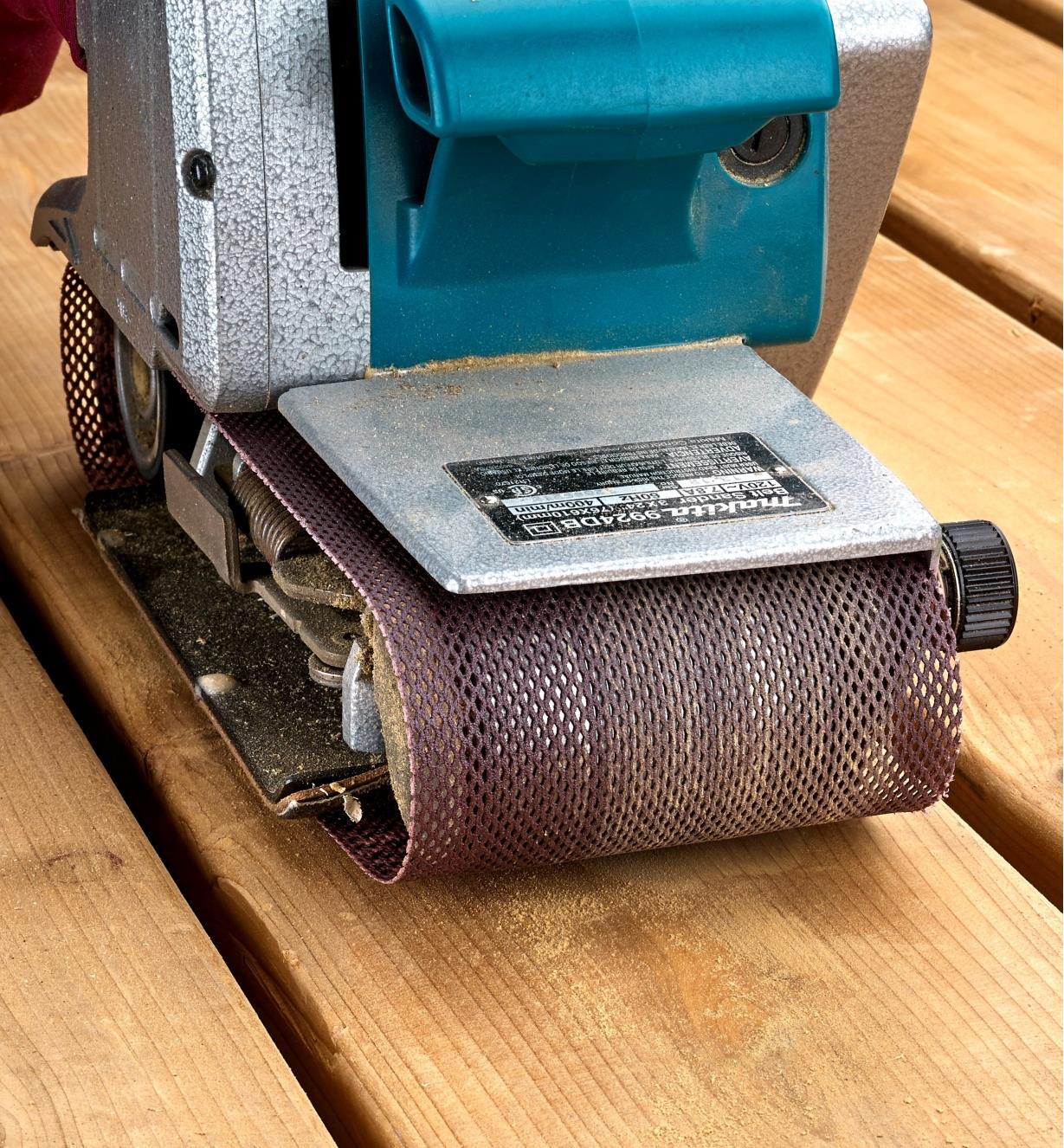 A Mirka Abranet belt on a belt sander being used to sand deck boards
