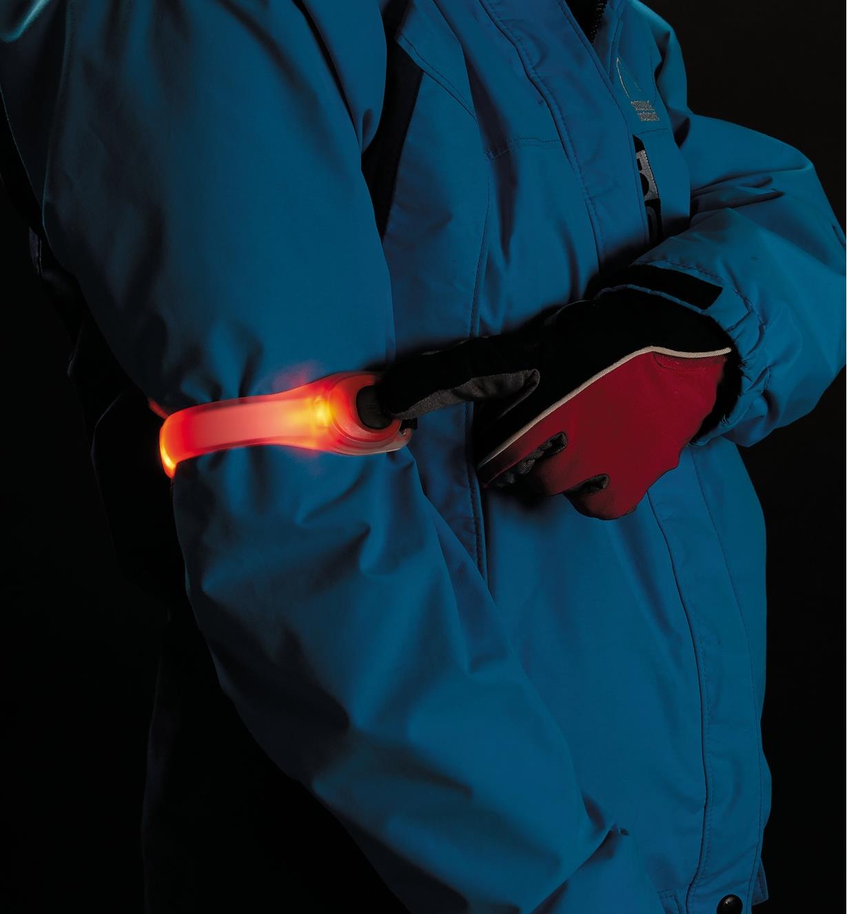 A person wearing the Red Wrap Light on their arm, pressing the button