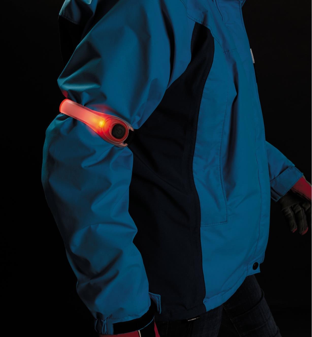 Red Wrap Light wrapped around the arm of a person's jacket at night