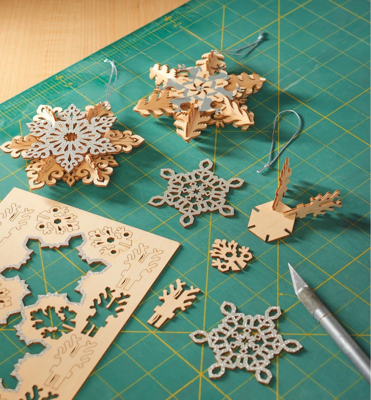 Two completed snowflake ornaments and one being made