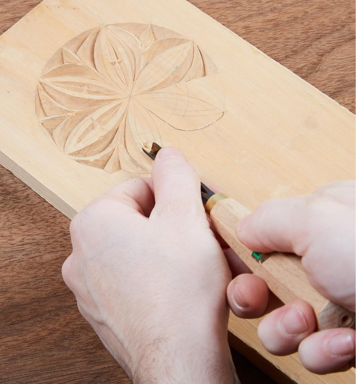 Using a gouge to remove wood in a relief carving