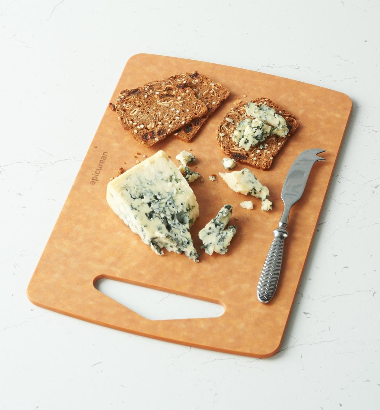 A knife, cheese and crackers on a Small Epicurean Prep Series Cutting Board