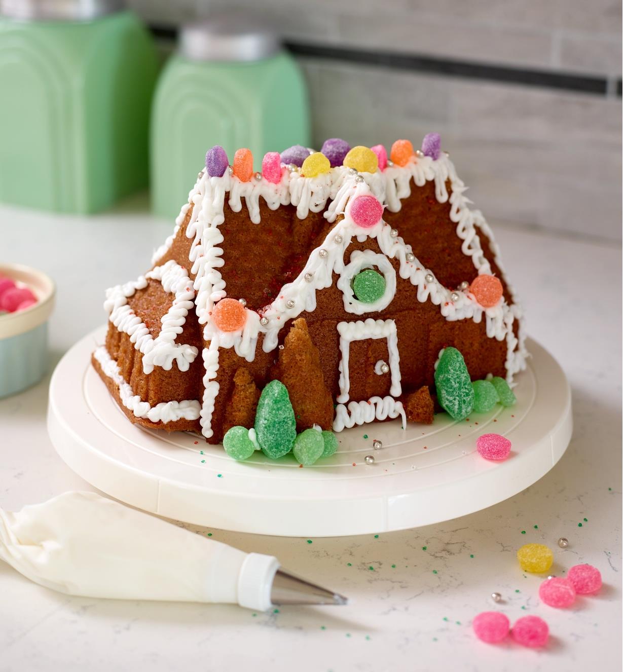 A gingerbread house cake decorated with icing and candy