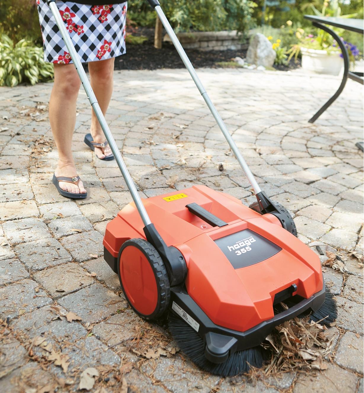 Using the Dual Brush Sweeper to clear debris off a patio