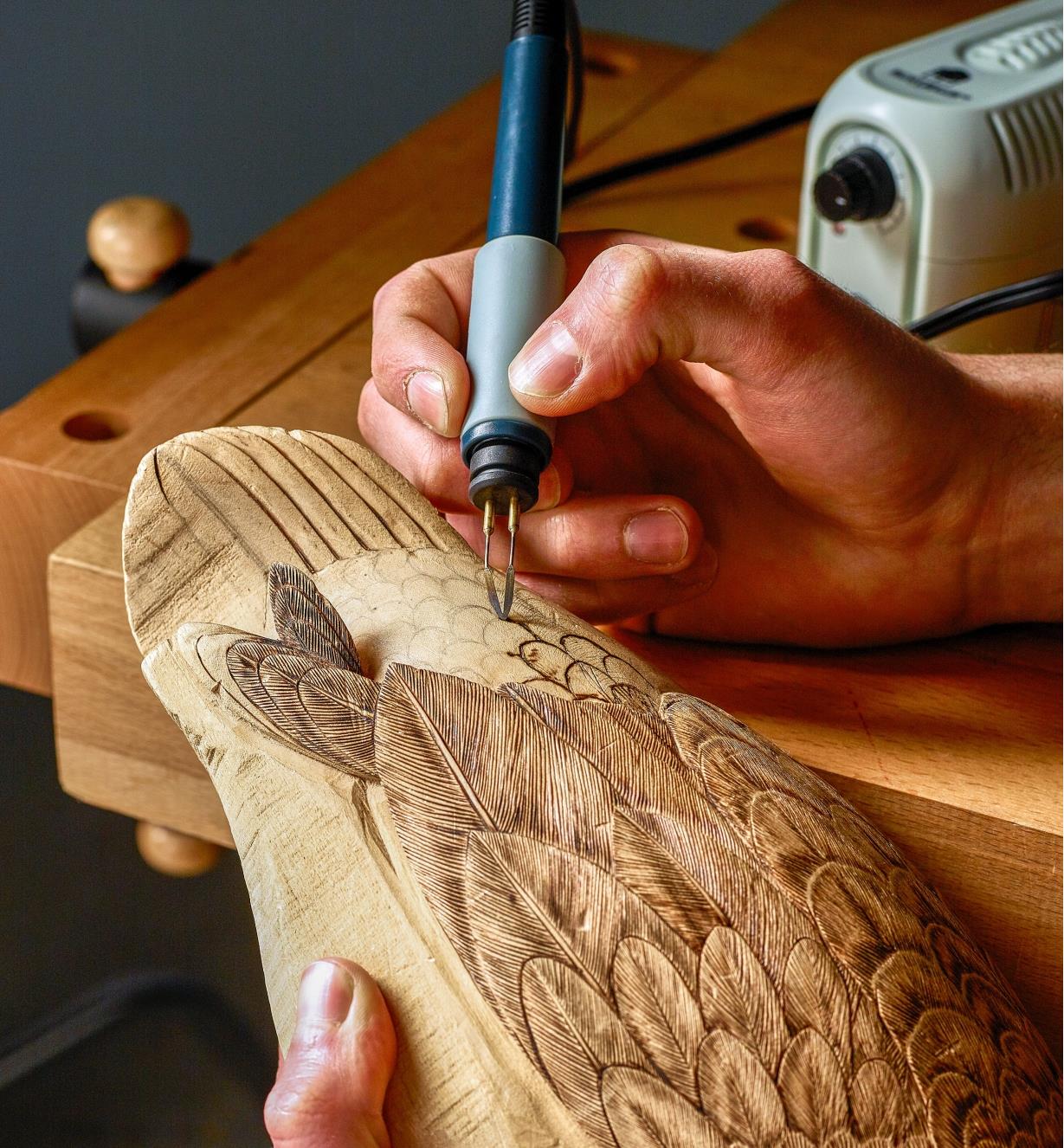 Burning feather designs onto a wooden duck