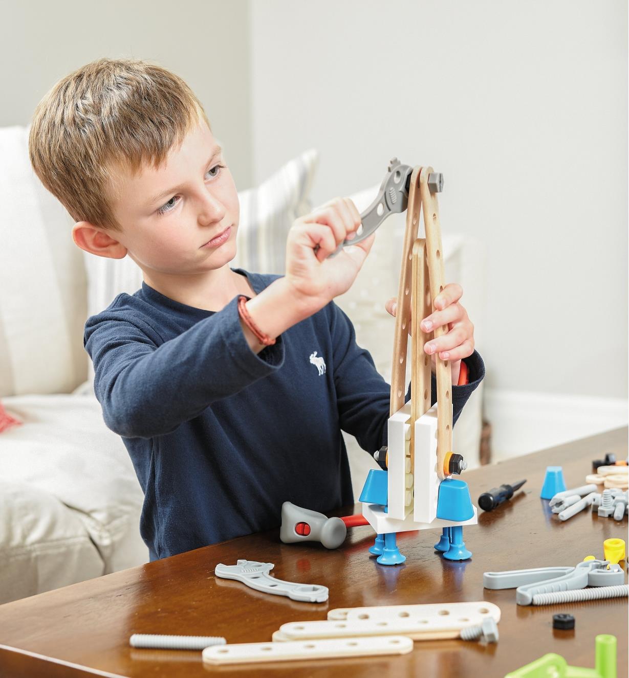 A boy building a rocket with the Brio Builder Construction Set