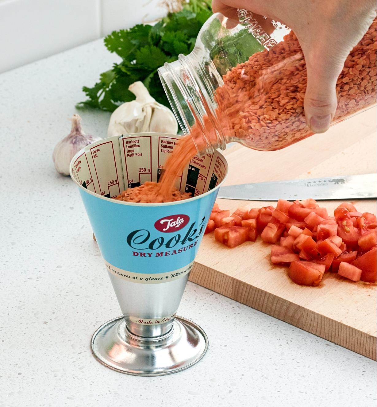 Pouring lentils into the Dry-Weight Measuring Cup, French