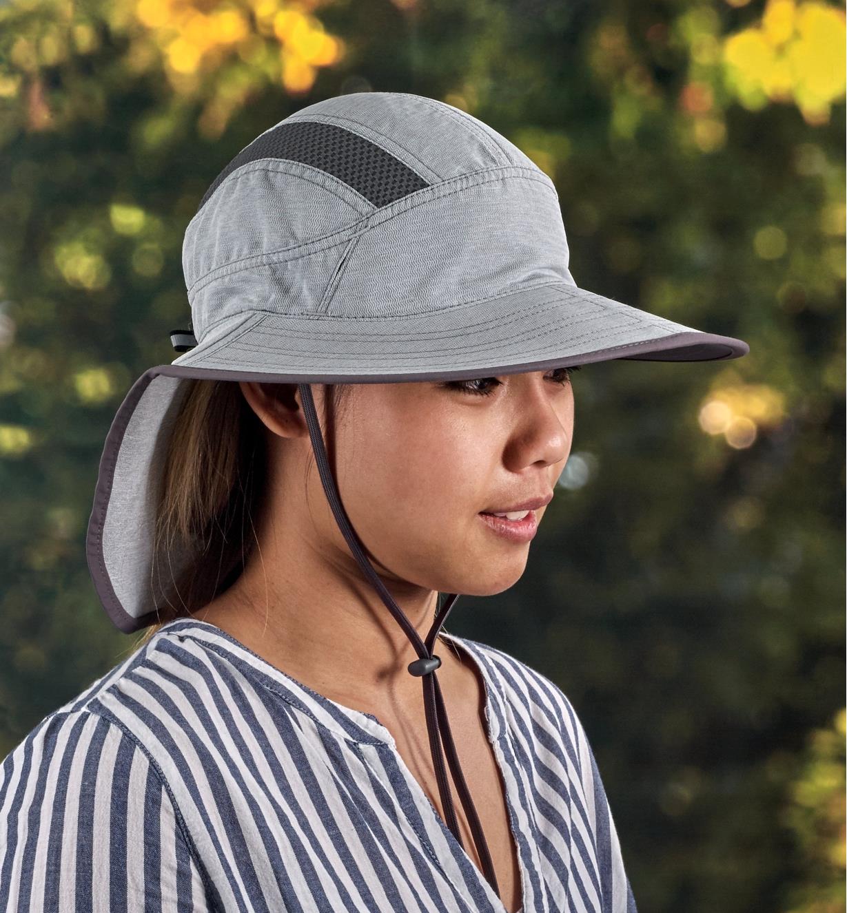 Side view of a woman wearing a light gray adventure sun hat