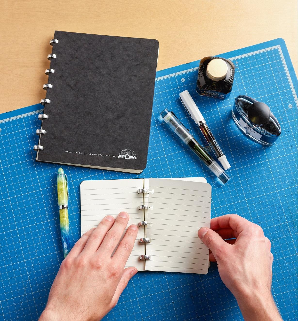 Removing a blank page from the small Atoma notebook, with the large notebook sitting close by