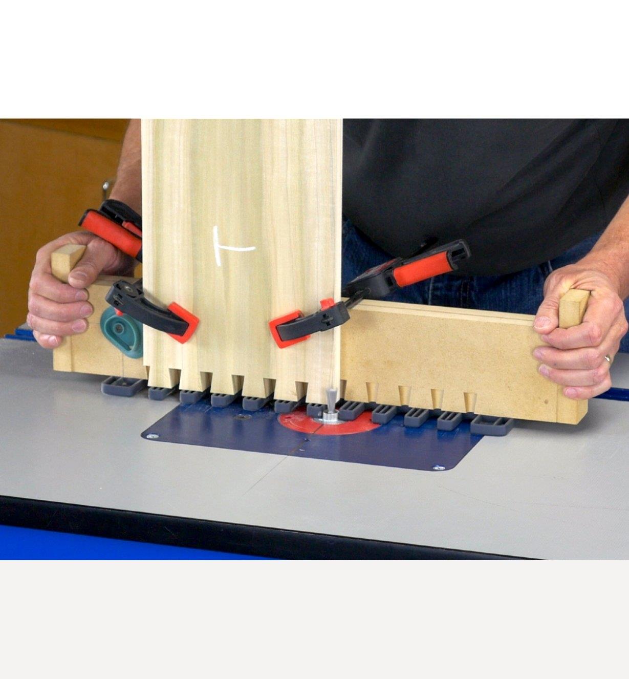 A man using the Leigh Through Dovetail Jig on a router table to cut dovetails