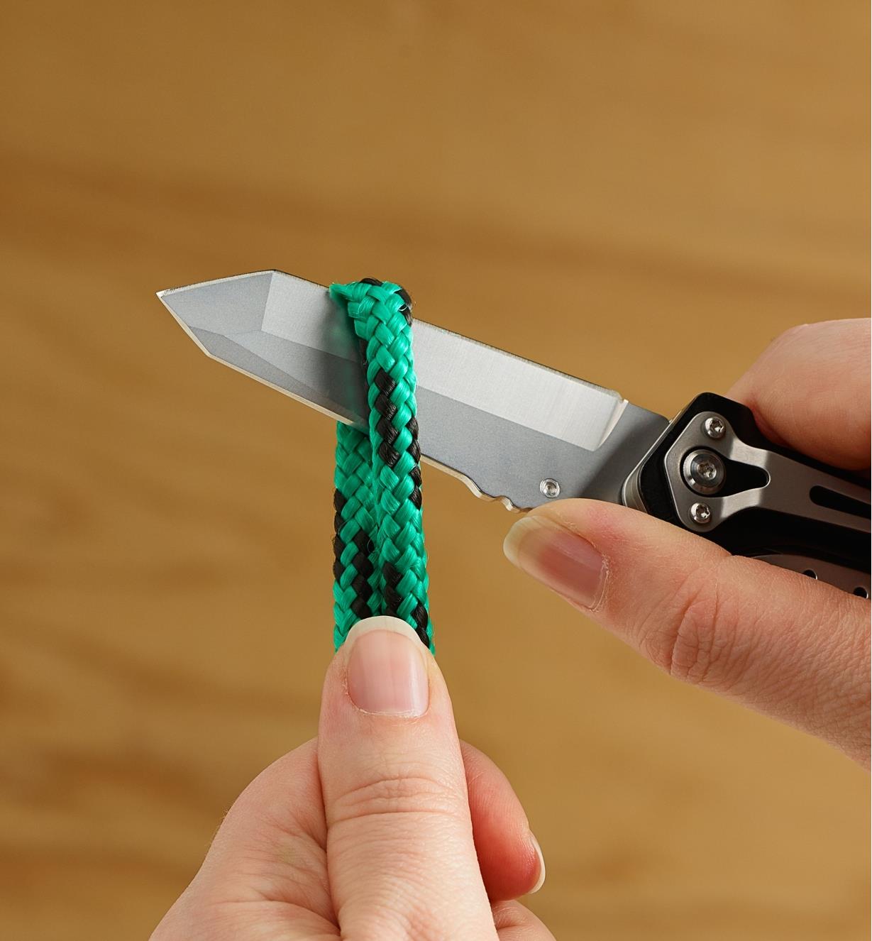Multi-tool knife cutting a length of rope