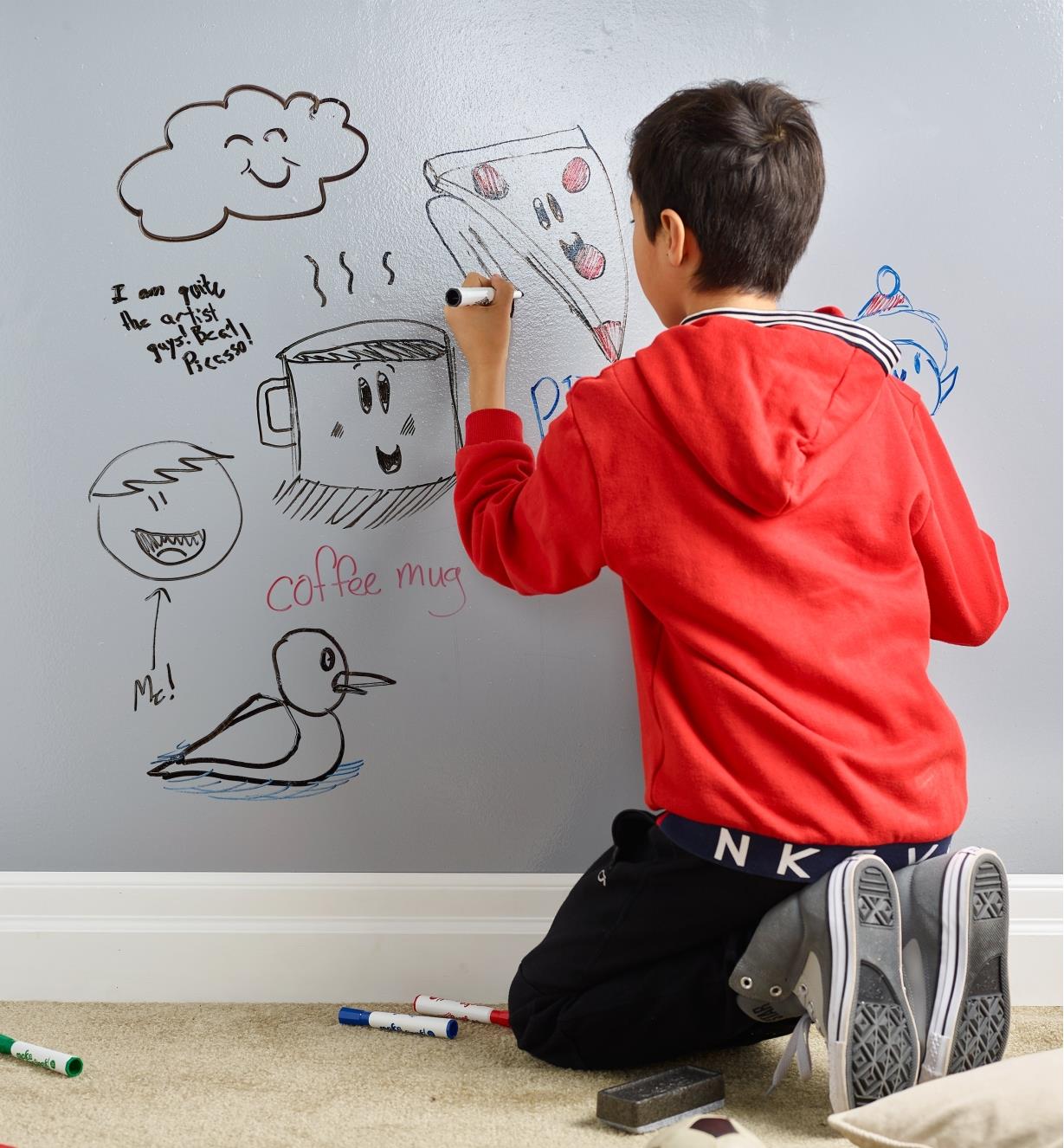 A child draws on a dry-erase wall created using the dry-erase surface kit 