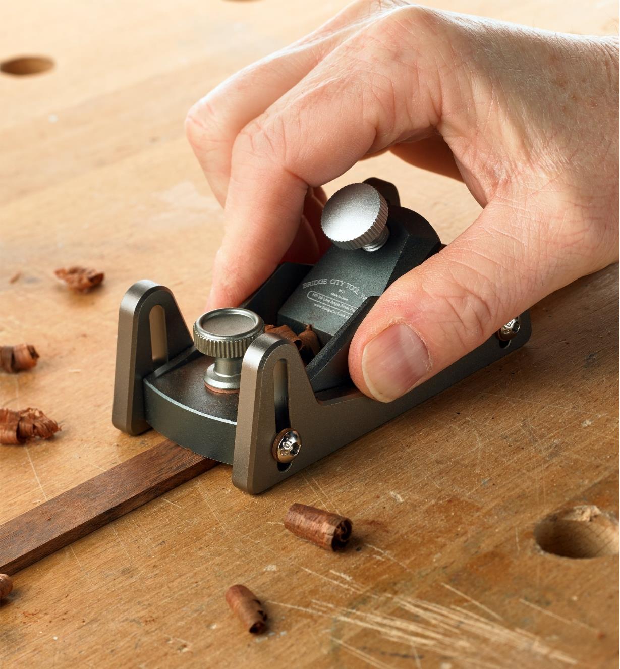 Using the block plane with skates attached to plane a piece of wooden inlay to the correct thickness