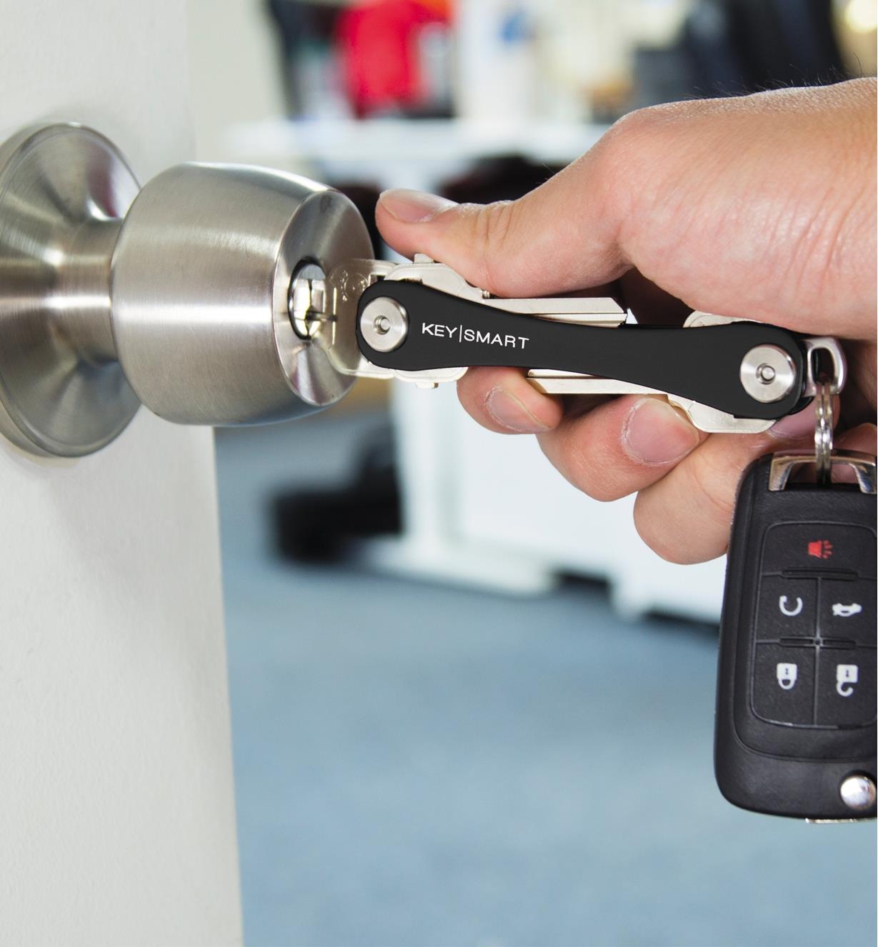 Unlocking a door with a key held in a KeySmart Rugged that is attached to a car key remote