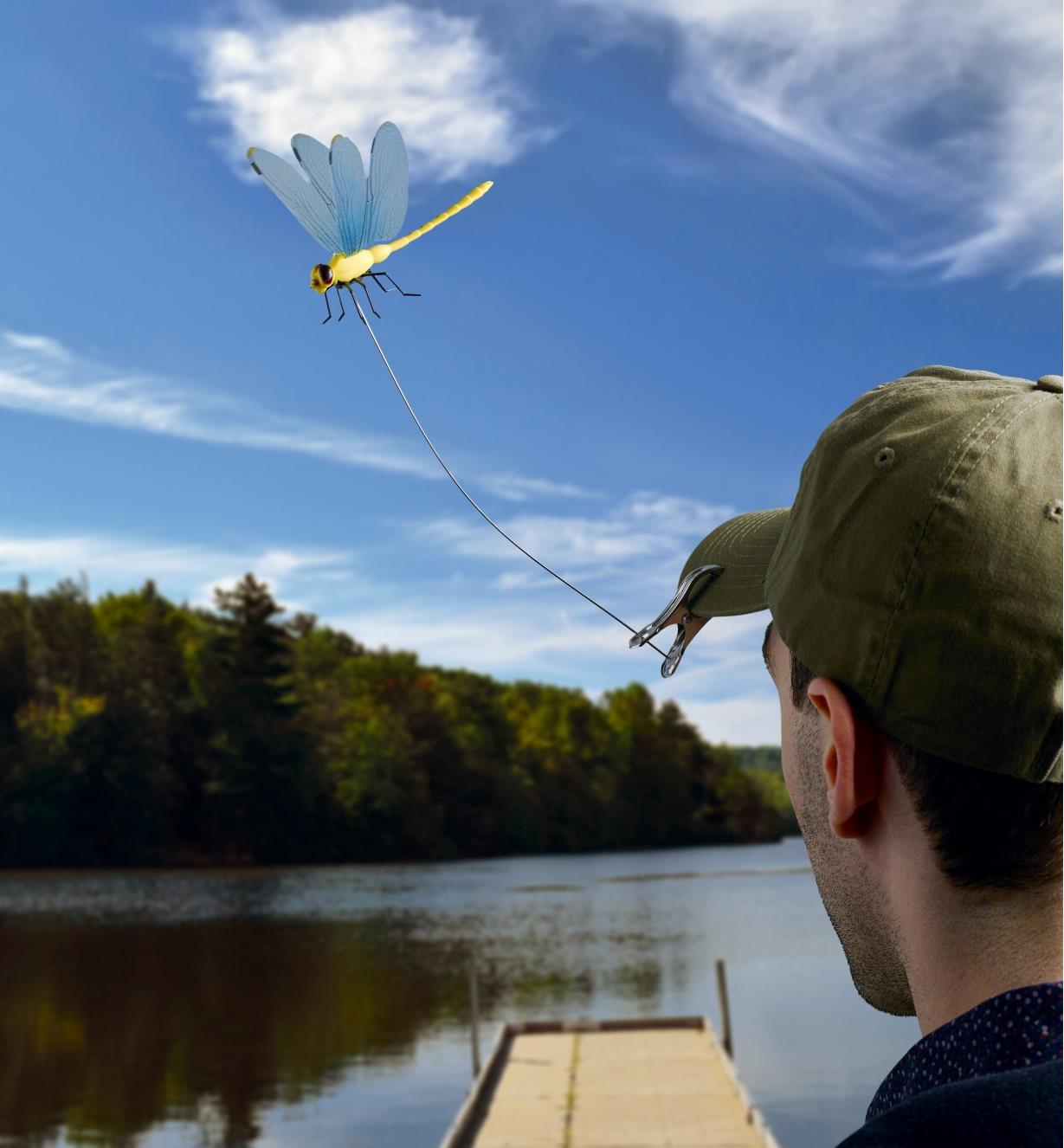 A man wears a ball cap with a Dragonfly Wingman deer fly and horsefly deterrent clipped to the peak