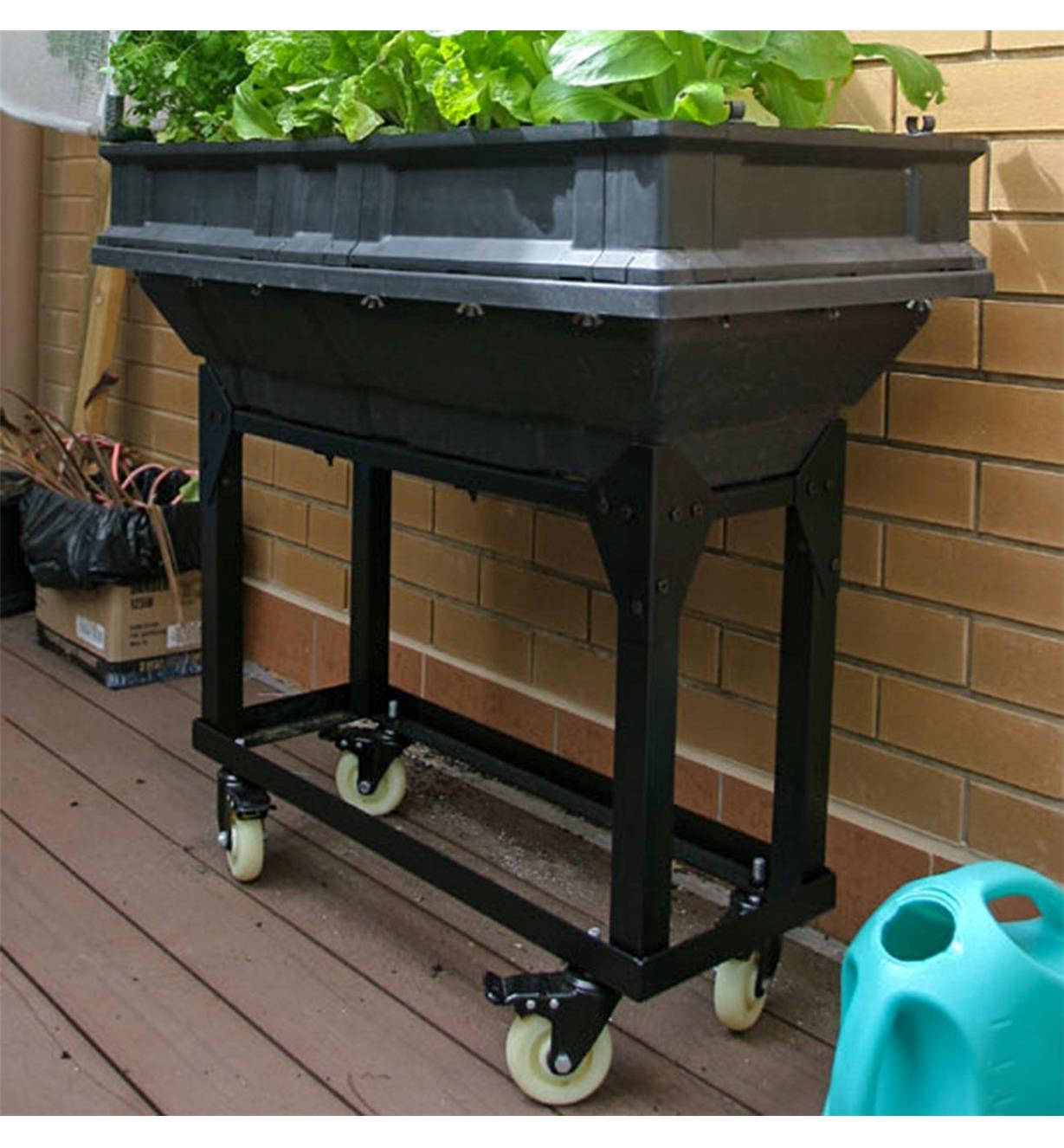 A Vegepod trolley stand supporting a small Vegepod container garden used to grow plants on a deck