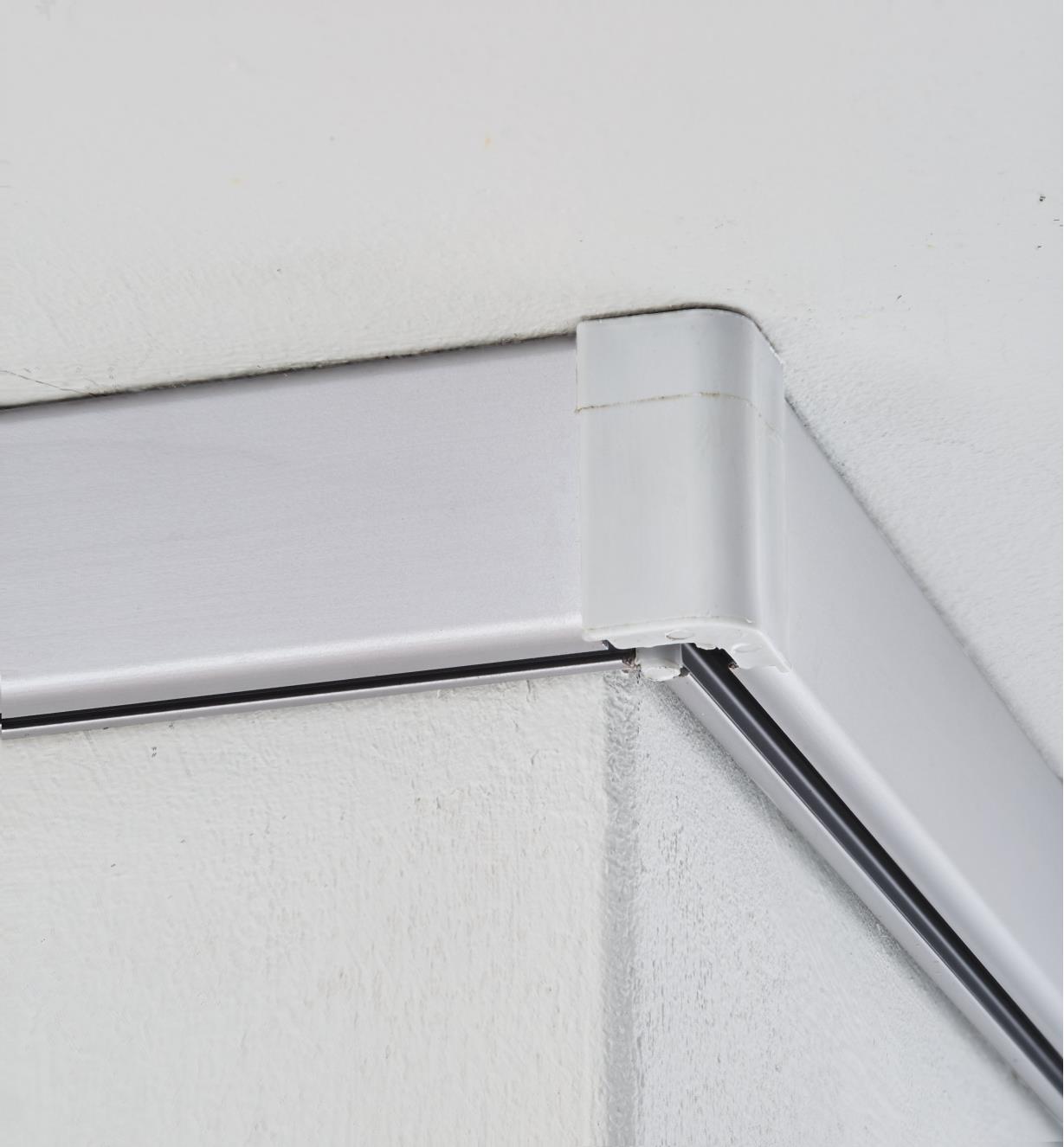 Example of Cliprail rail corner cap joining two support rails at a ceiling corner