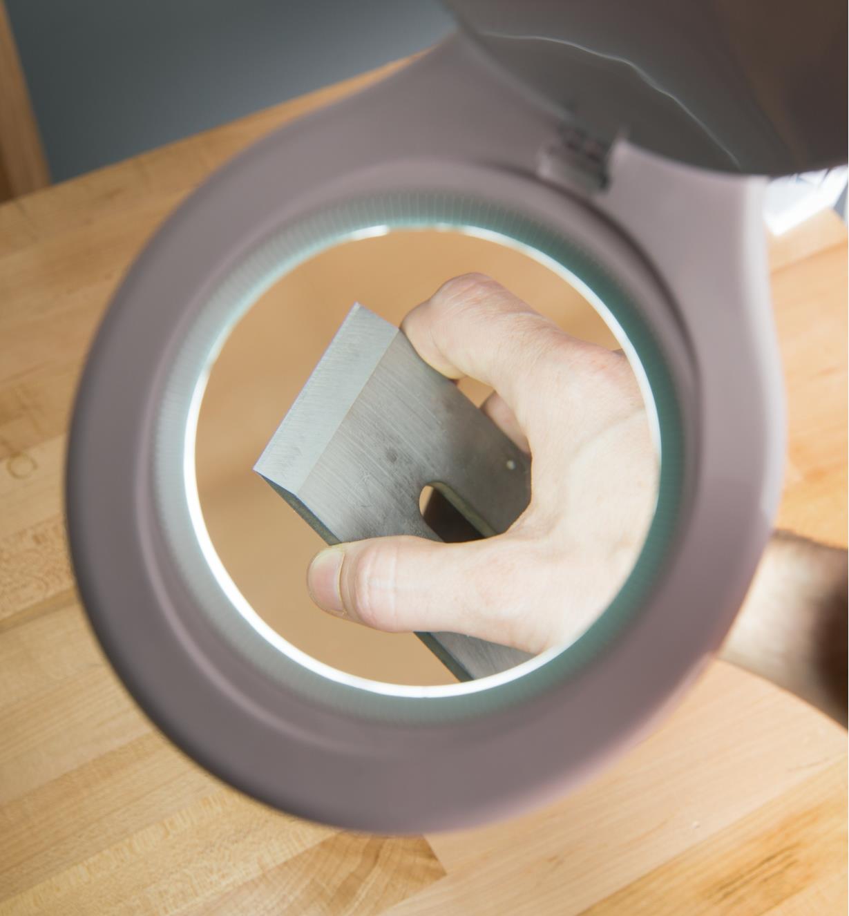Close-up view of the lamp magnifying a plane blade