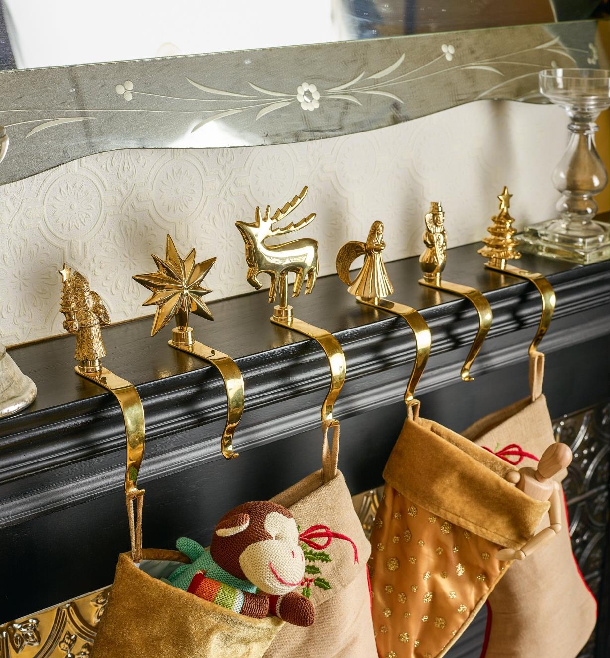Set of 6 Brass Hangers holding stockings on a mantel