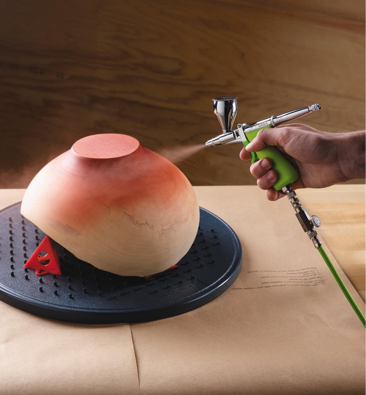 Spraying paint on the bottom of a bowl with the Grex Airbrush Kit with Top-Mount Cup