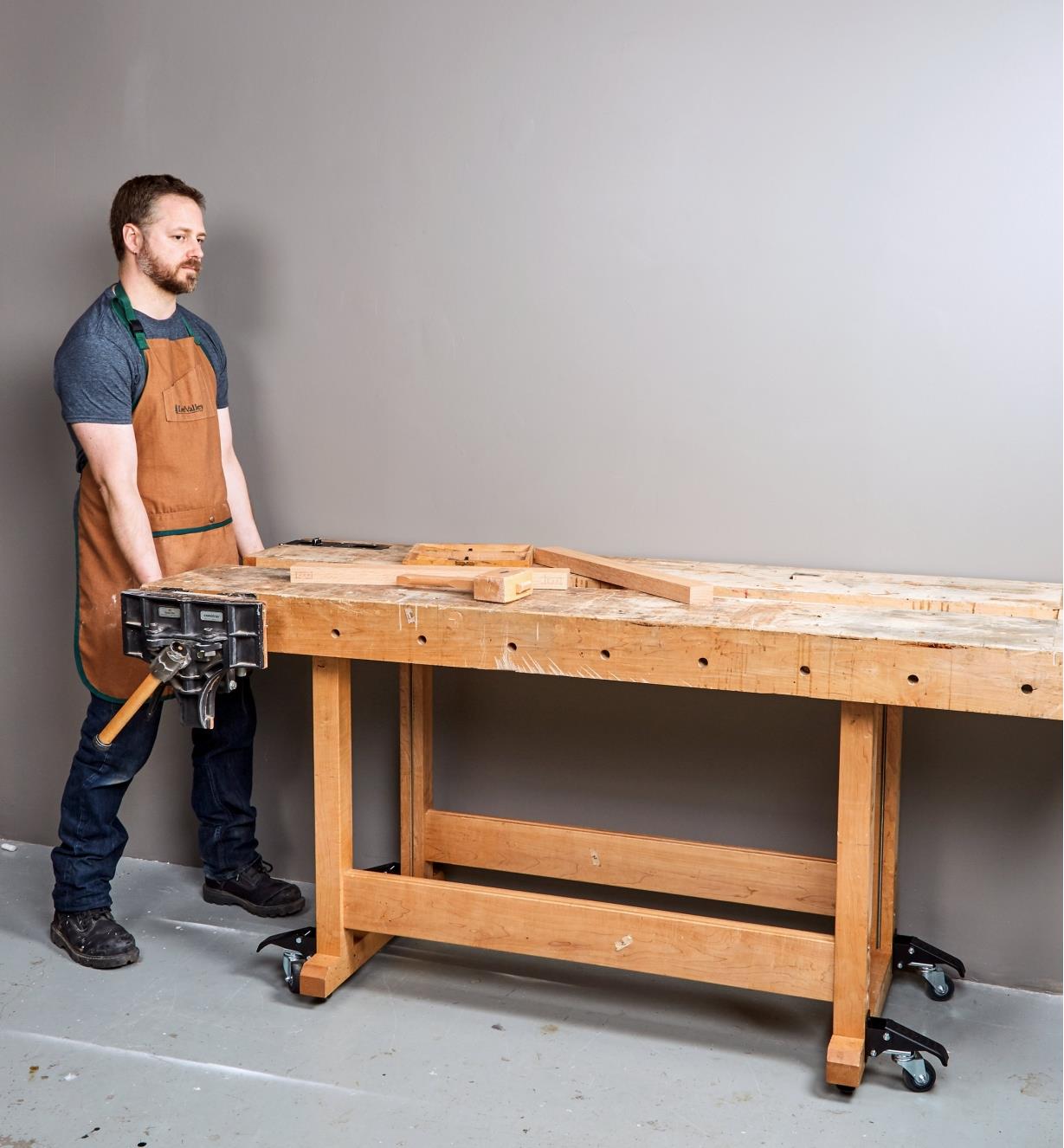 Rolling a workbench into position on a set of four workbench casters